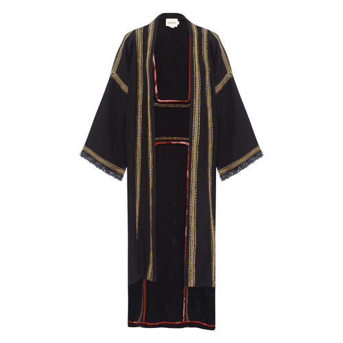 A model wearing a black and gold embroidered Savanah coat with fraying at the cuffs, sitting elegantly. On Sale